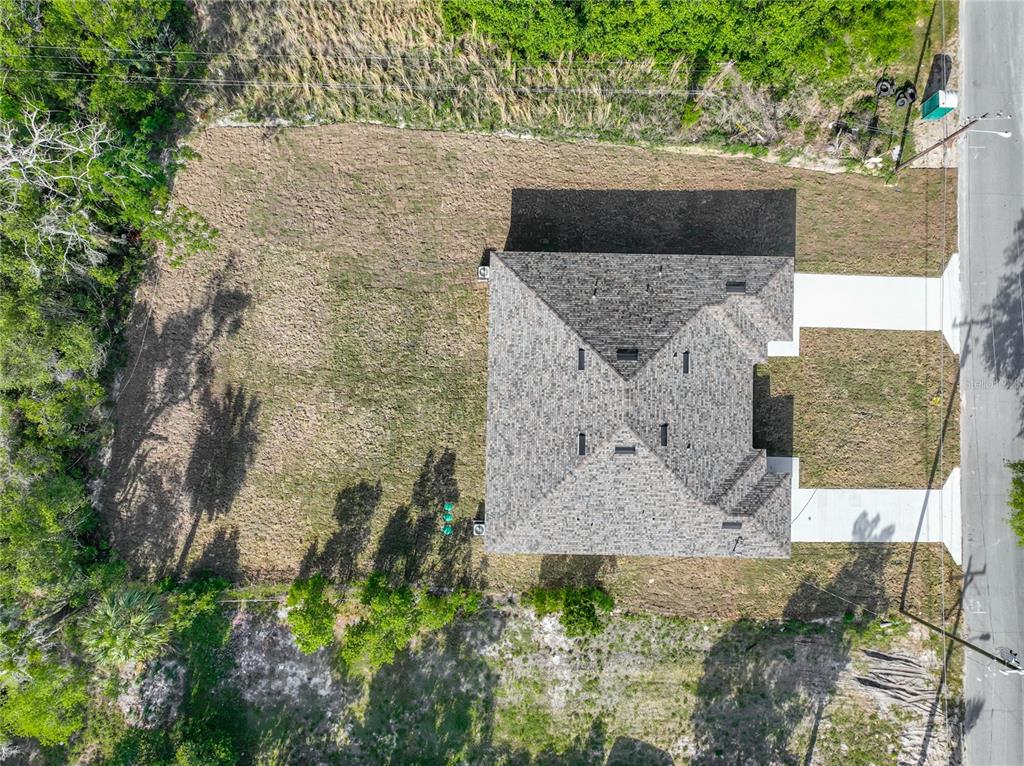 An aerial view shows a newly constructed house with a gray roof on a lot — 356 W 4TH STREET, APOPKA, FL