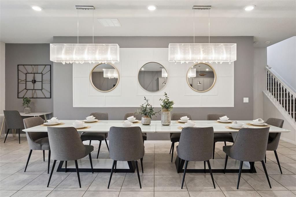 A dining room features a long white table, gray chairs, and three circular wall mirrors — 3621 LILY LANE, DAVENPORT, FL