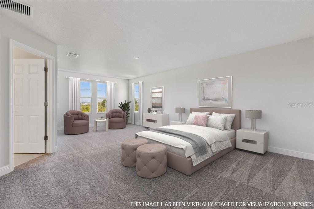 This virtually staged bedroom features gray carpeting, a bed, two armchairs, and white walls — 9711 SURREY ROSE DRIVE, SAN ANTONIO, FL