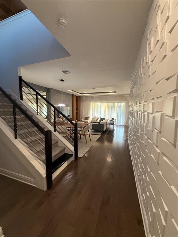 A hallway with a textured wall leads to a dining and living area with stairs — 8289 TOPSAIL PLACE, WINTER GARDEN, FL