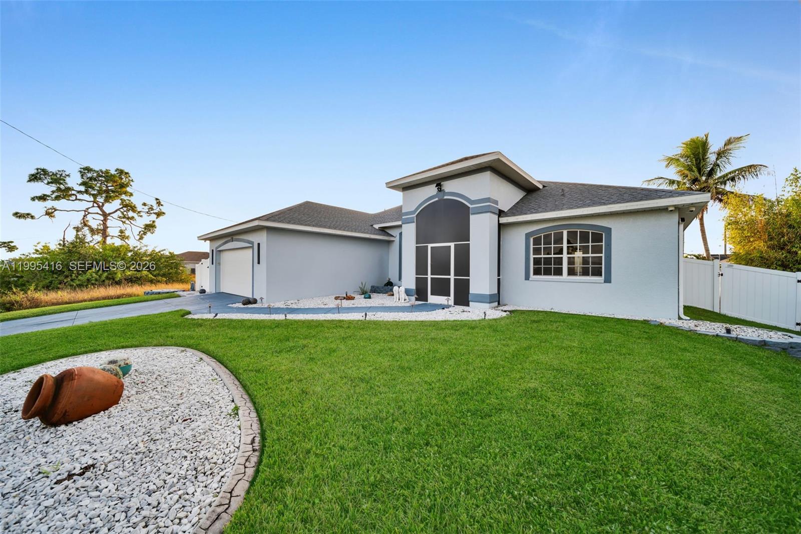 A single-story house with a light gray exterior, a garage, and a landscaped front yard — 1024 NW 23, Cape Coral FL 33993, CAPE CORAL, FL