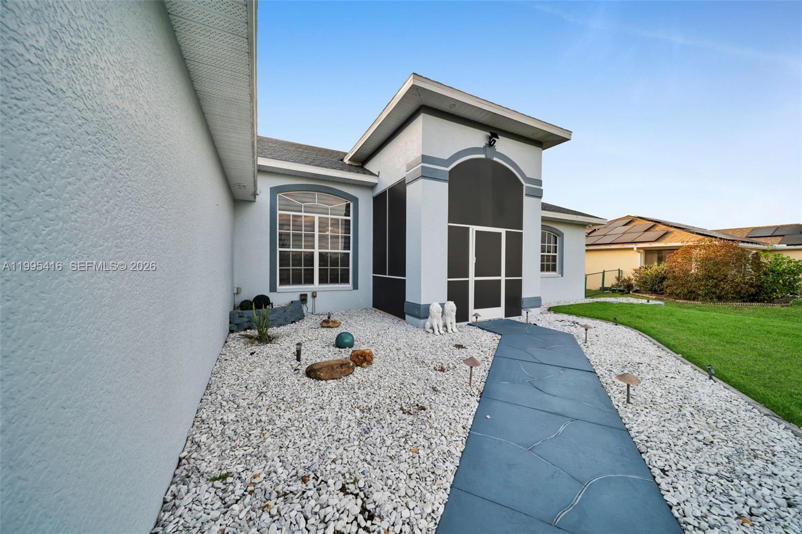 The exterior view shows a house with a screened entryway, gravel landscaping, and a walkway — 1024 NW 23, Cape Coral FL 33993, CAPE CORAL, FL