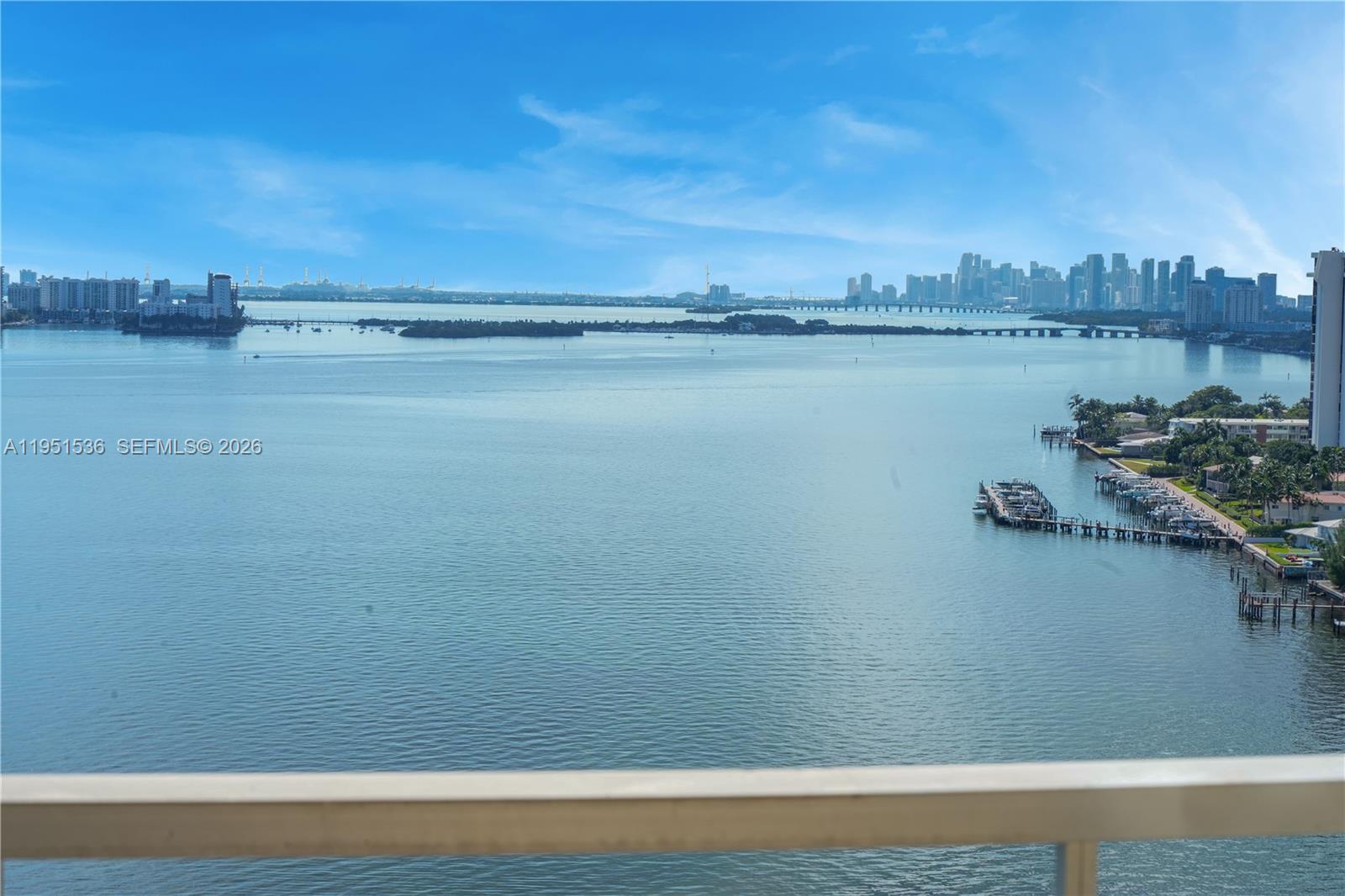 An elevated view of a bay with a distant city skyline and a boat dock — 11111 Biscayne Blvd # 21C, Miami FL 33181, MIAMI, FL