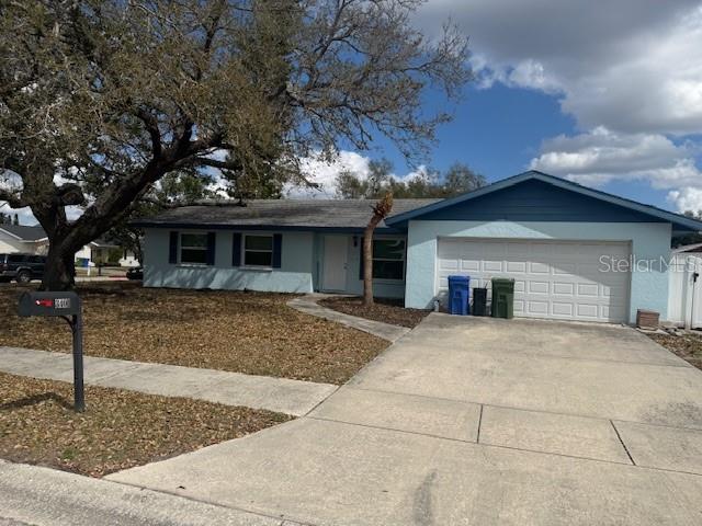 A single-story house with a light blue exterior, a two-car garage, and a large tree — 3401 50TH STREET W, BRADENTON, FL