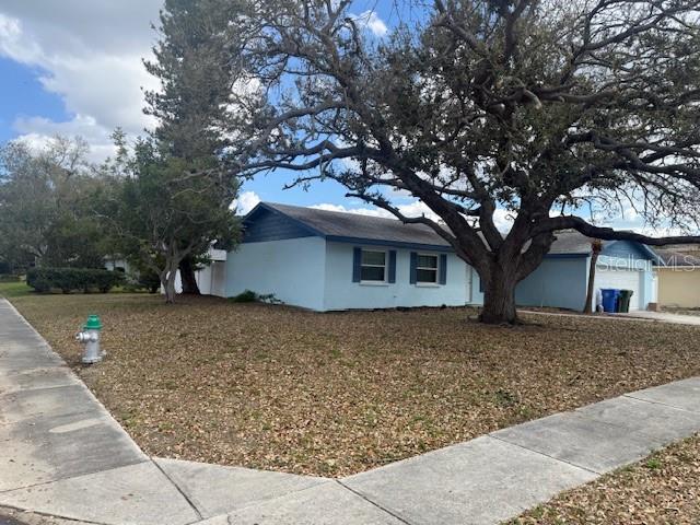 A light blue single-story house sits on a corner lot with a large oak tree — 3401 50TH STREET W, BRADENTON, FL