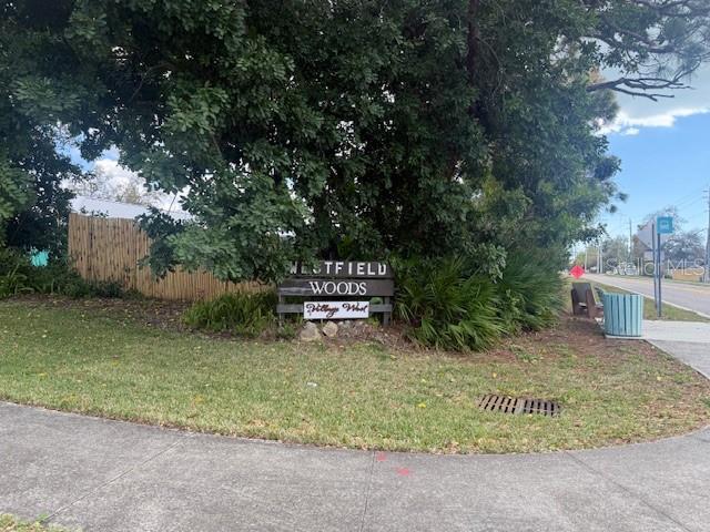 A wooden sign for Westfield Woods stands in a grassy area near a sidewalk — 3401 50TH STREET W, BRADENTON, FL