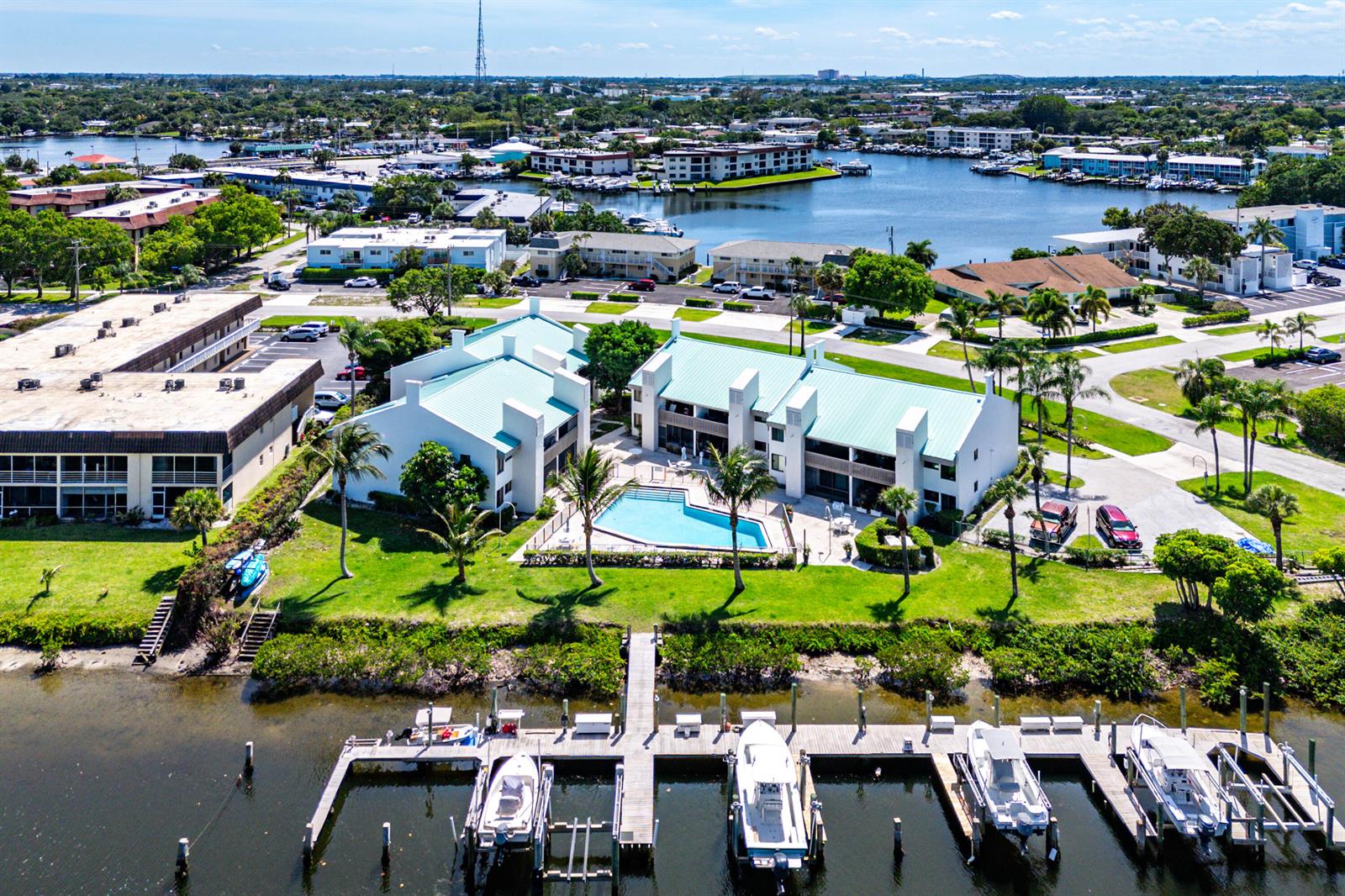 An aerial view shows a waterfront apartment complex with a swimming pool and boat docks — 412 Southwind Drive # B2, North Palm Beach FL 33408, NORTH PALM BEACH, FL