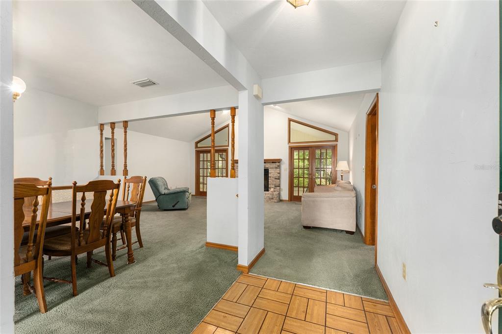 An entryway with tiled flooring leads into a carpeted dining area and living room — 7027 NW 51ST TERRACE, GAINESVILLE, FL