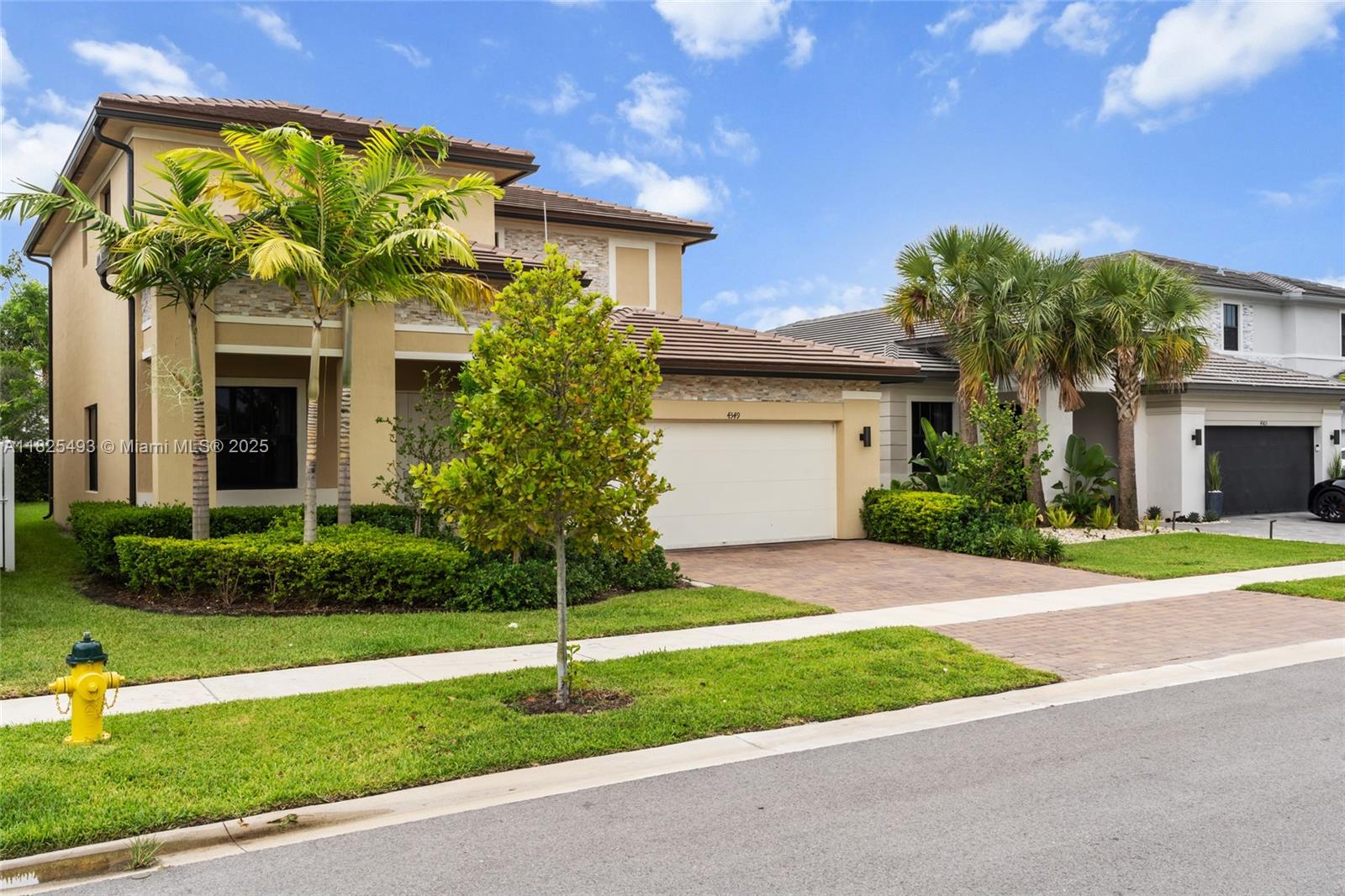 A two-story tan house with a tile roof, a two-car garage, and palm trees — 4349 SW 173rd Ave, Miramar FL 33029, MIRAMAR, FL