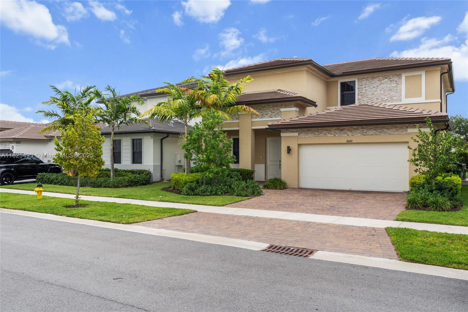 A two-story suburban house features a tan stucco exterior, stone accents, and a paved driveway — 4349 SW 173rd Ave, Miramar FL 33029, MIRAMAR, FL