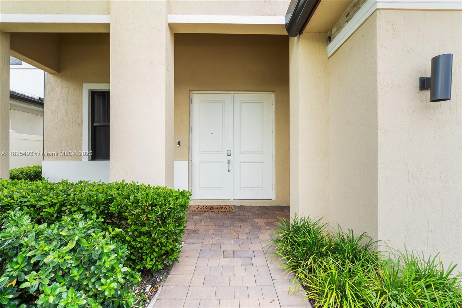 A paved walkway leads to a double-door entrance of a beige stucco house — 4349 SW 173rd Ave, Miramar FL 33029, MIRAMAR, FL