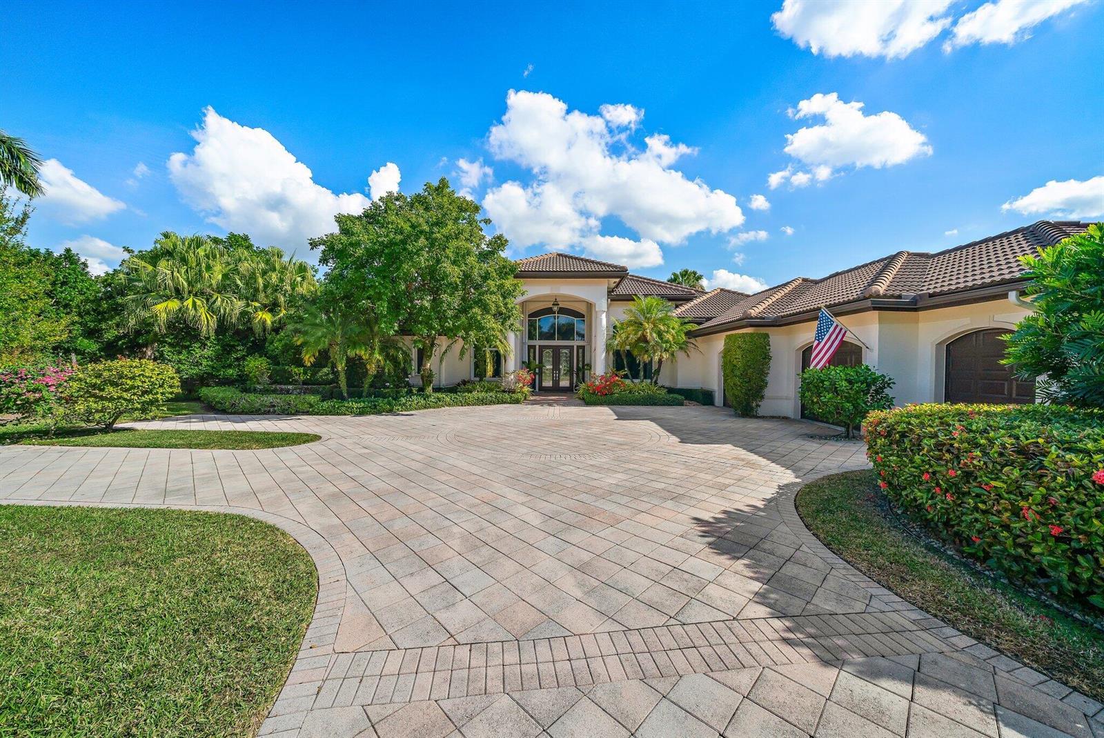 A large single-story house with a paved circular driveway and an American flag — 8010 Fairway Lane, West Palm Beach FL 33412, WEST PALM BEACH, FL