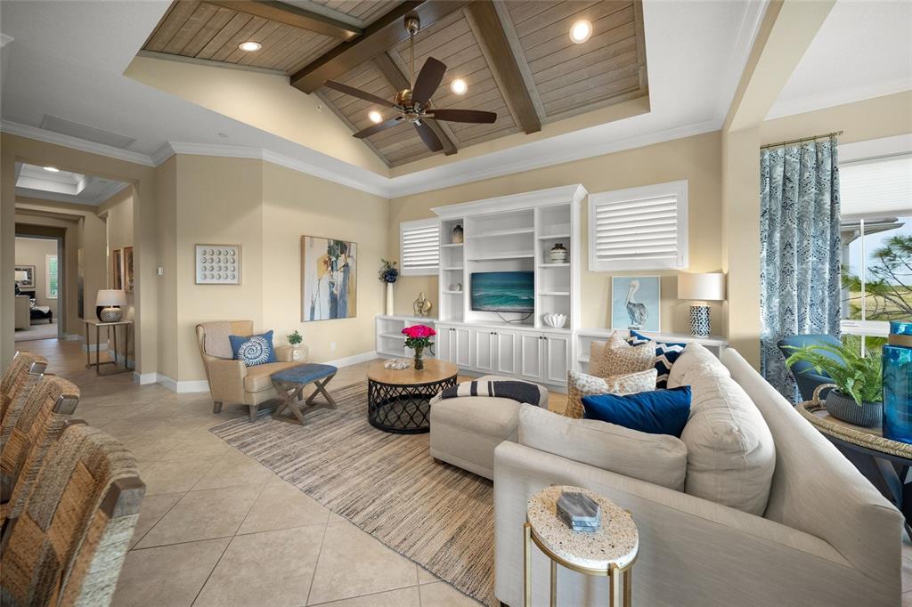 A living room features a vaulted wood-paneled ceiling, built-in shelving, and tile flooring — 229 SAPPHIRE LAKE DRIVE UNIT 201, BRADENTON, FL