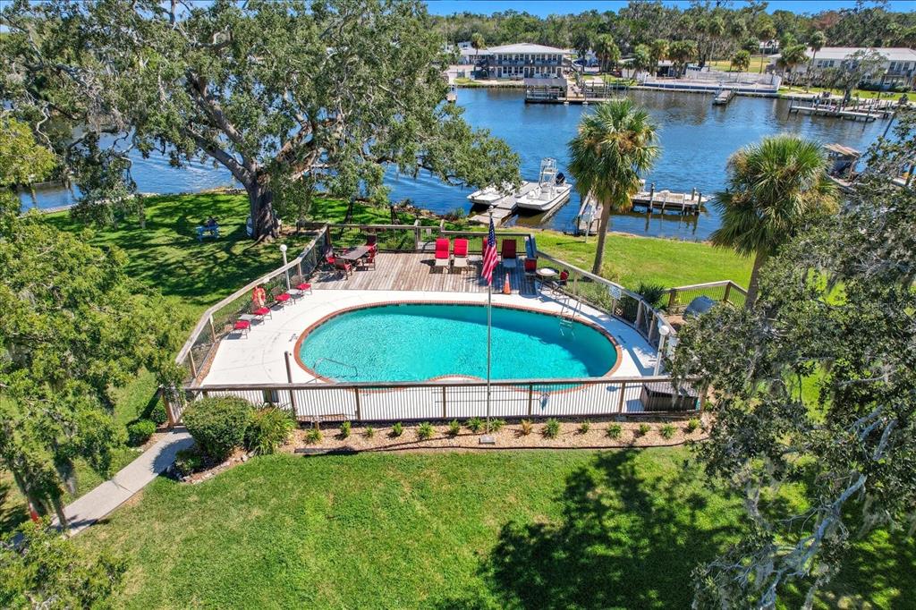 An aerial view of a fenced swimming pool and deck overlooking a river with docks — 5152 S SWIFTWATER WAY, HOMOSASSA, FL
