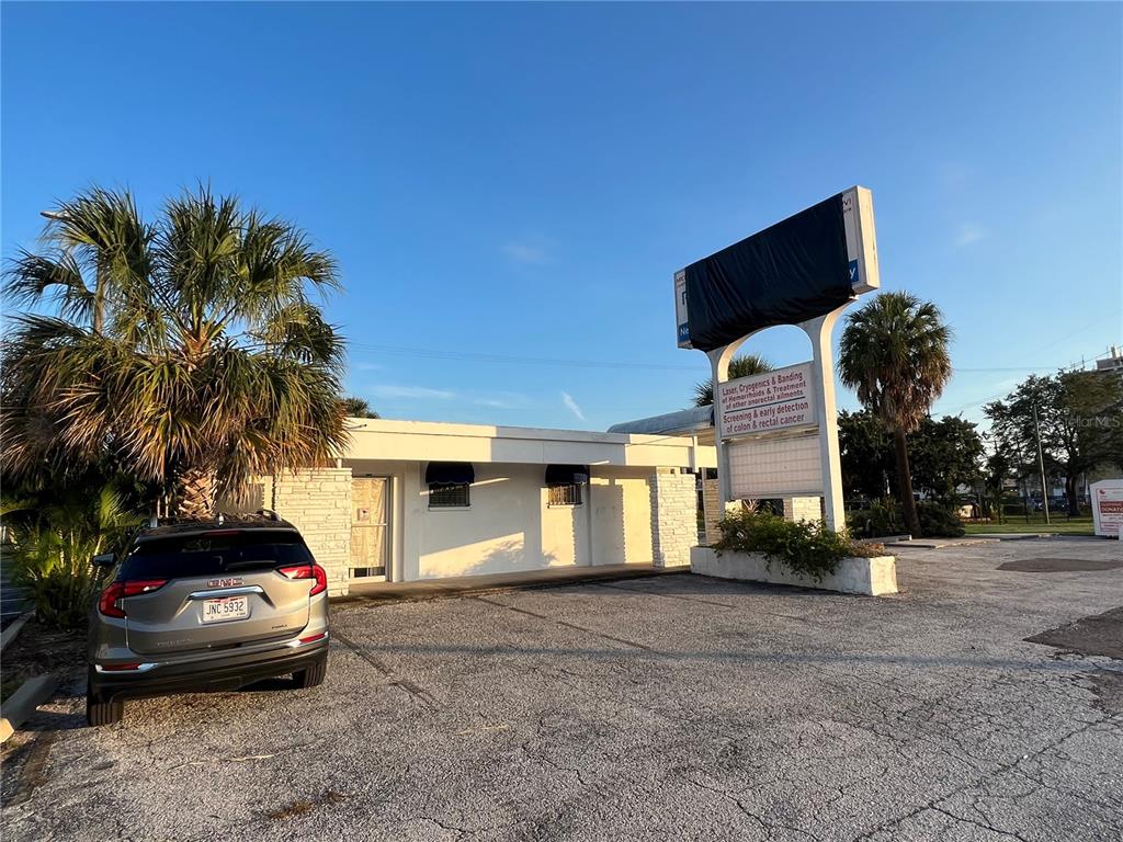 A single-story commercial building with a parking lot and a tall sign stands outside — 3901 HENDERSON BOULEVARD, TAMPA, FL
