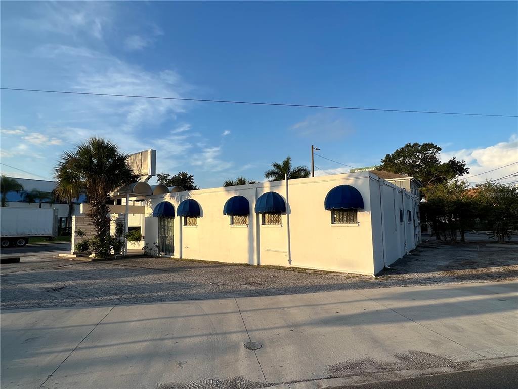 A single-story white commercial building features blue arched awnings over its windows and entrance — 3901 HENDERSON BOULEVARD, TAMPA, FL