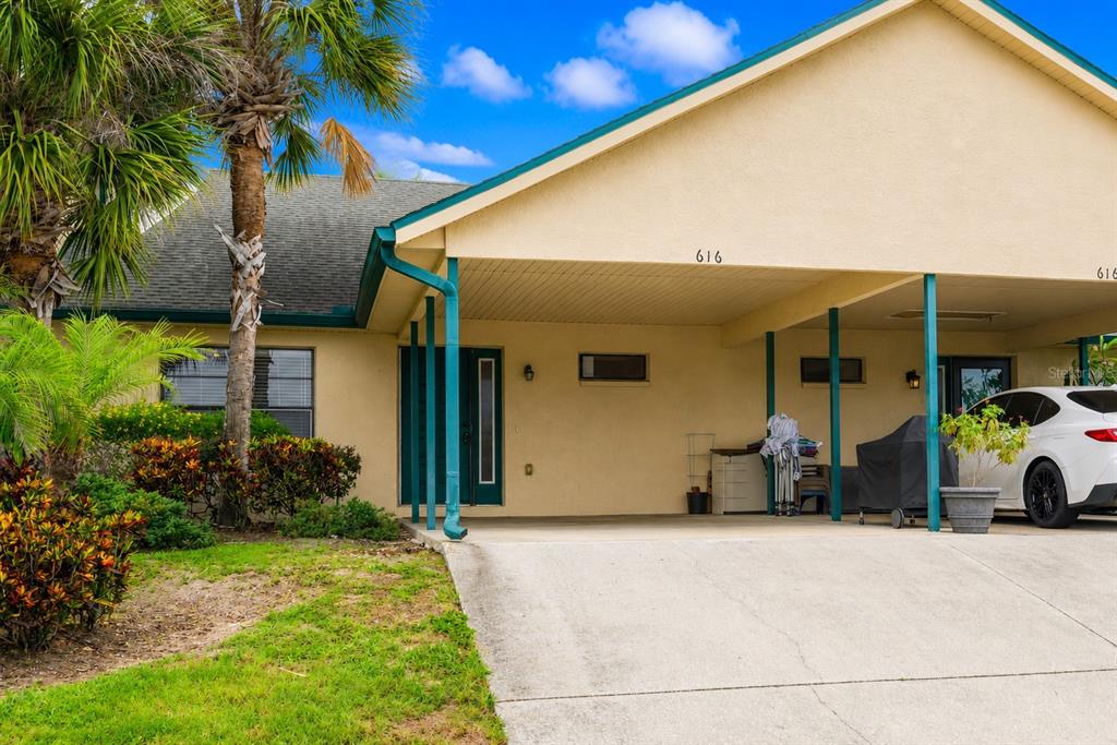 A tan house with a covered carport and a palm tree in the front yard — 616 YARDARM DRIVE UNIT 8, APOLLO BEACH, FL