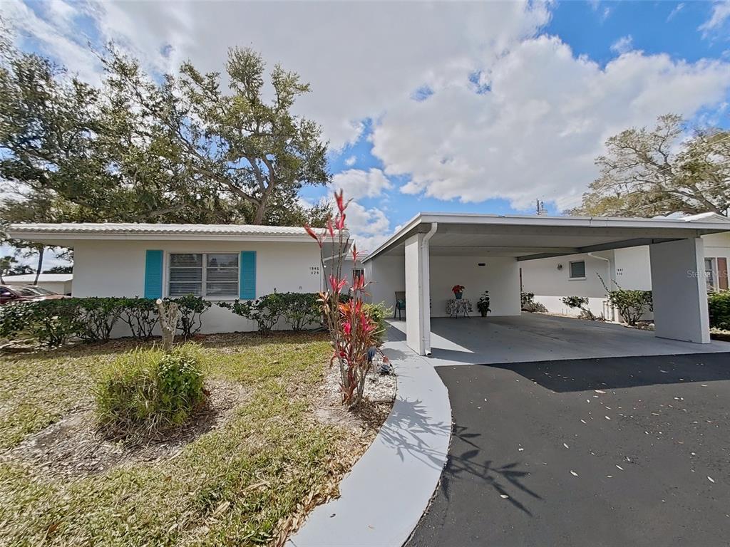 A single-story house with a white exterior, blue shutters, and an attached carport — 1845 VERA PLACE UNIT 29, SARASOTA, FL