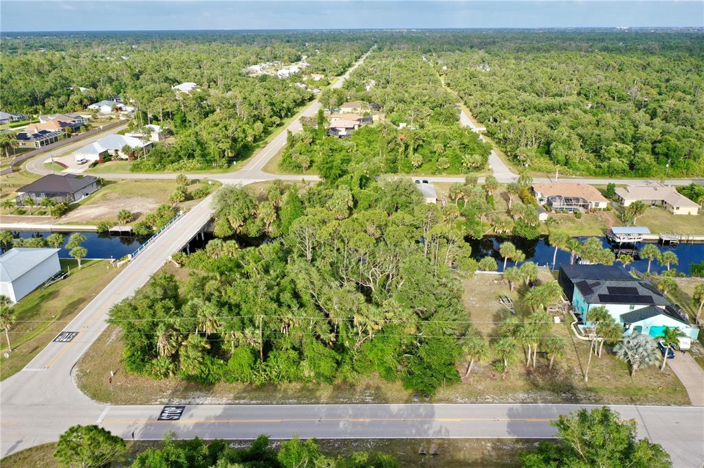 An aerial view shows a wooded lot situated between a road and a canal — 3020 COMO STREET, PORT CHARLOTTE, FL