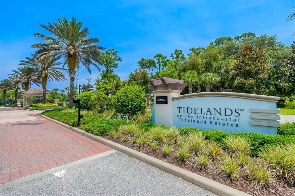 A stone entrance sign for Tidelands on the Intracoastal stands beside a brick paved road — 85 RIVERVIEW BEND S UNIT 1532, PALM COAST, FL