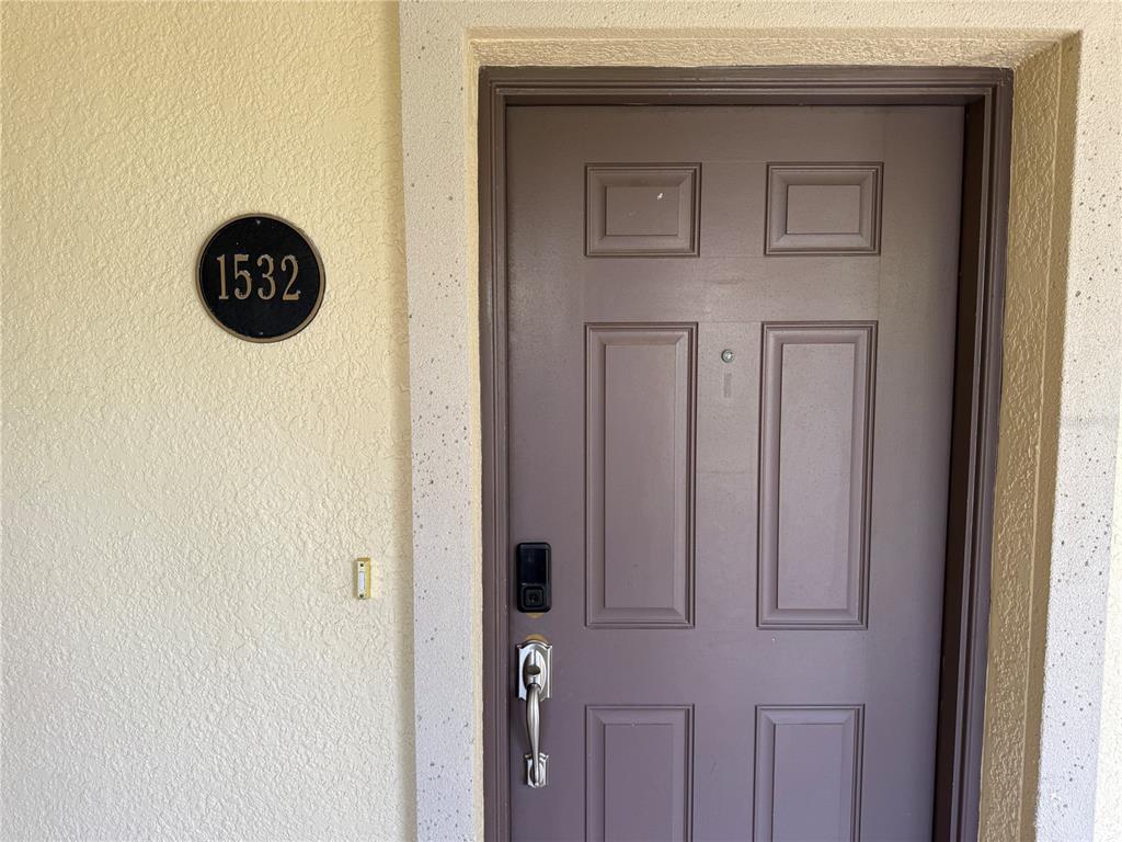 A brown front door with a digital lock and a circular unit number sign — 85 RIVERVIEW BEND S UNIT 1532, PALM COAST, FL