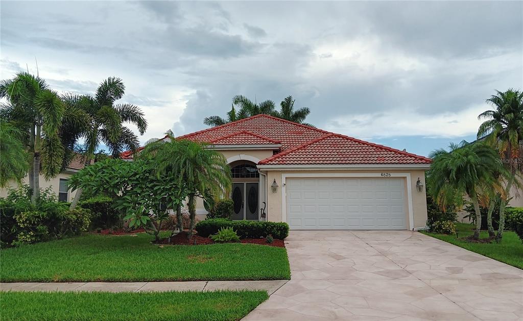 A single-story house with a red tile roof, a two-car garage, and palm trees — 6828 WINSLOW STREET, SARASOTA, FL