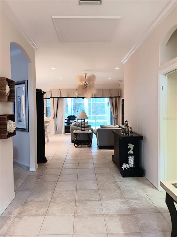 A tiled hallway leads into a living room with a ceiling fan and sliding glass doors — 6828 WINSLOW STREET, SARASOTA, FL