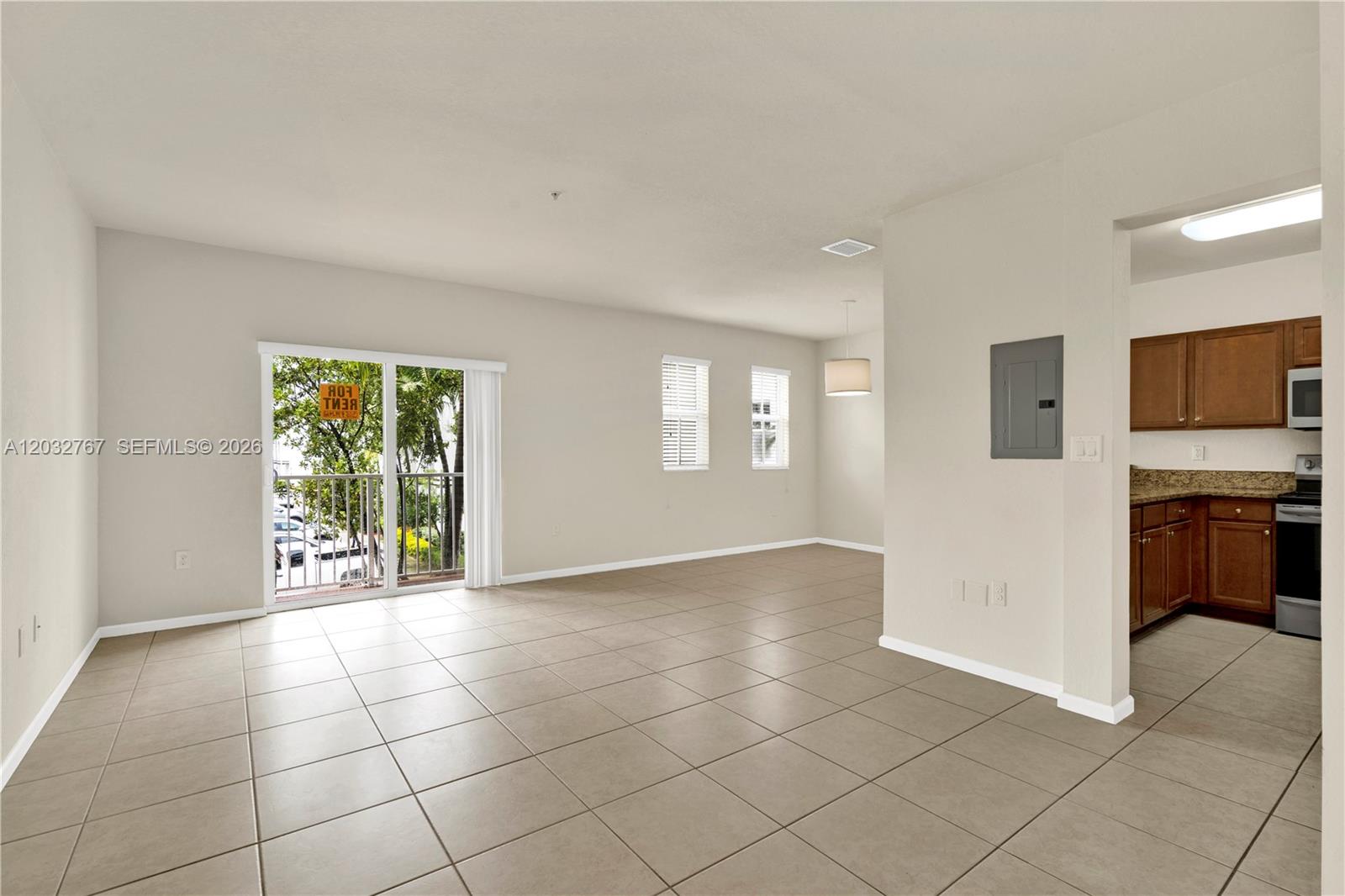 An open-concept living area features light tile flooring, neutral walls, and an adjacent kitchen — 8620 NW 97th Ave # 213, Doral FL 33178, DORAL, FL