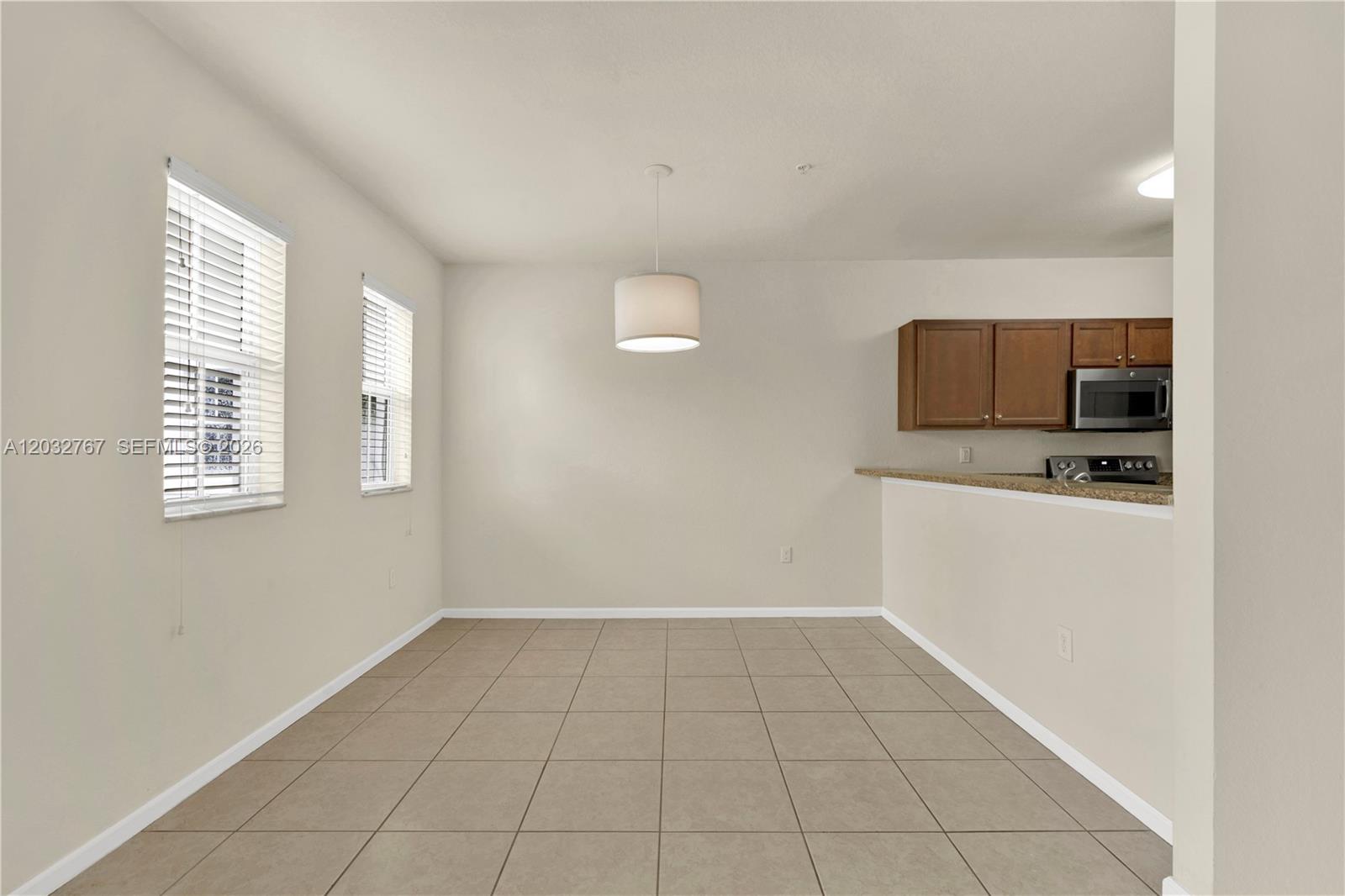 An empty dining area features tile flooring, a pendant light, and an adjacent kitchen counter — 8620 NW 97th Ave # 213, Doral FL 33178, DORAL, FL