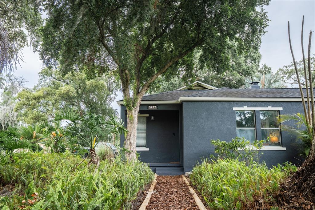 A dark gray house with a mulch walkway and lush landscaping under a large tree — 795 30TH STREET, ORLANDO, FL