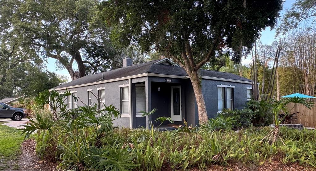 A single-story gray house with a dark roof is surrounded by lush green landscaping — 795 30TH STREET, ORLANDO, FL