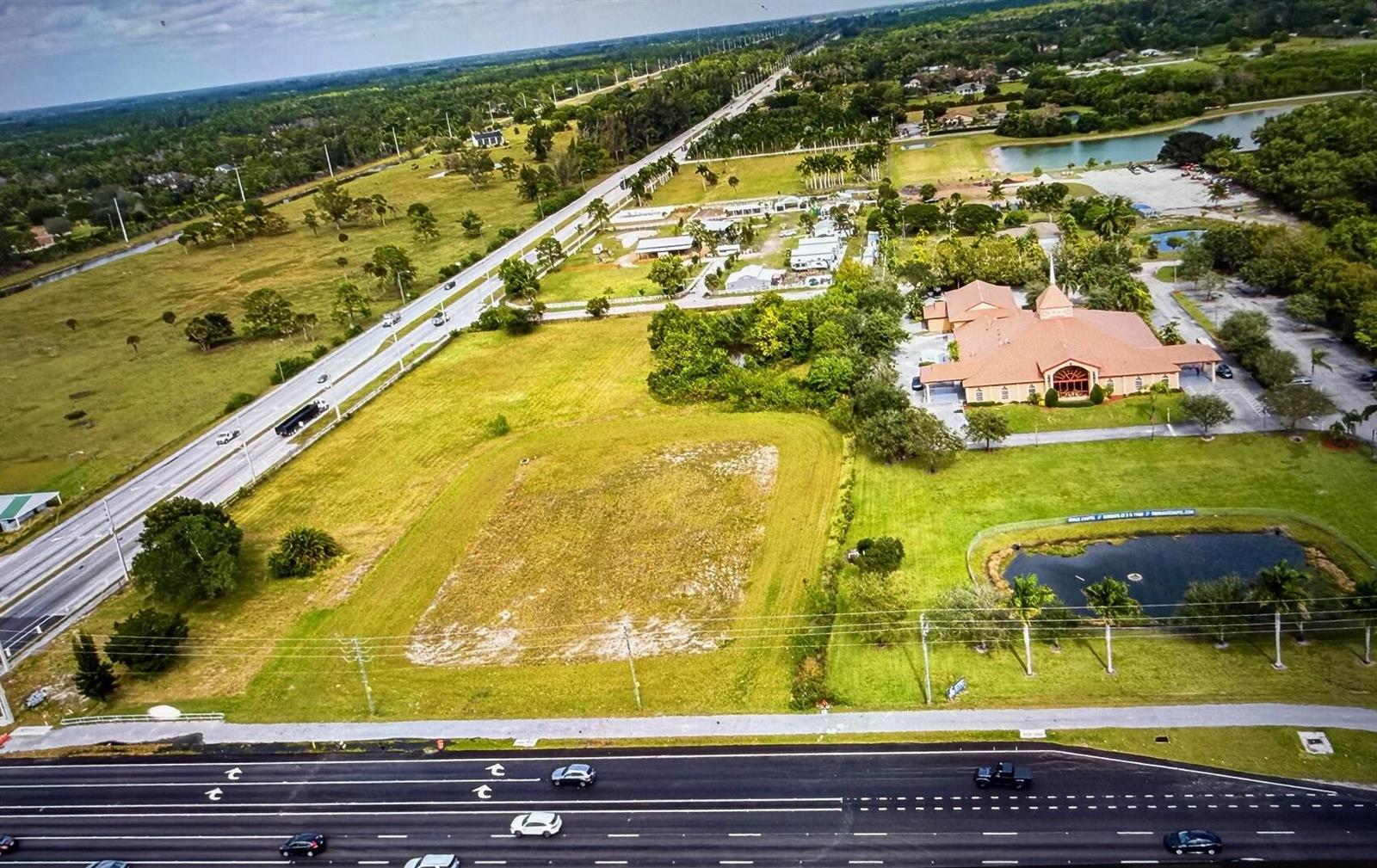 An aerial view shows a vacant rectangular lot next to a church and a highway — 16670 Rembrandt Road, Wellington FL, WELLINGTON, FL