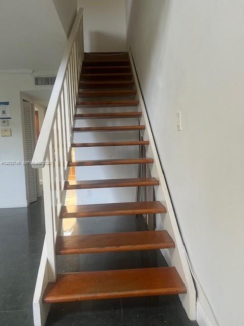 A wooden staircase with white railings leads upward in a room with dark tile flooring — 17911 NW 68th Ave # P208, Hialeah FL 33015, HIALEAH, FL