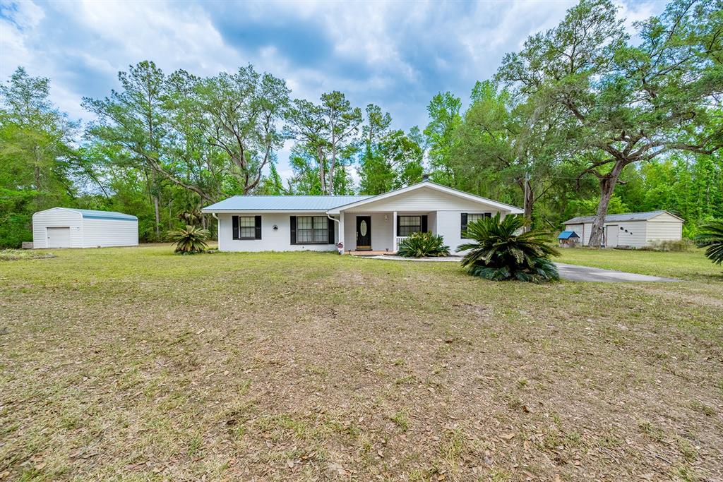 A single-story white house with a metal roof sits on a large, grassy lot — 1753 SE HIGHWAY 349, OLD TOWN, FL