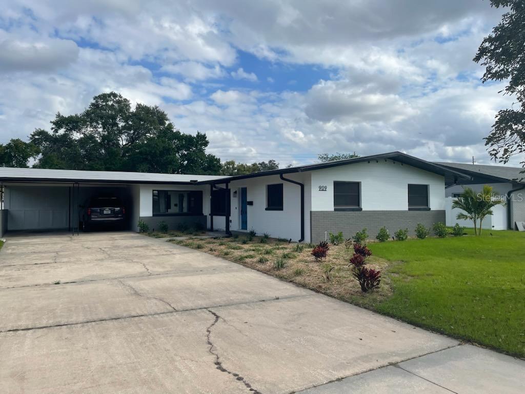 A single-story house with a white and gray brick exterior, a carport, and a driveway — 909 MARABON AVENUE, ORLANDO, FL
