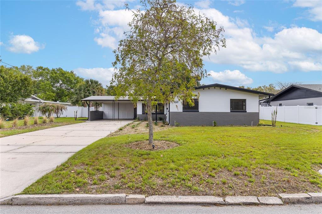A single-story house with a white and gray exterior, a carport, and a front lawn — 909 MARABON AVENUE, ORLANDO, FL