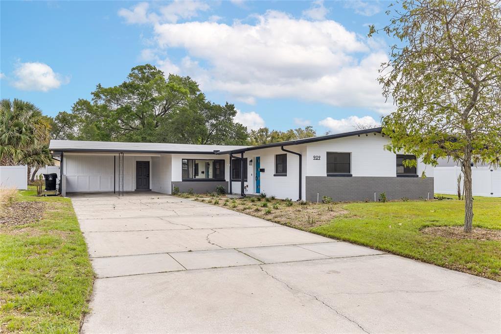 A single-story house with a white exterior, gray brick accents, and a covered carport — 909 MARABON AVENUE, ORLANDO, FL
