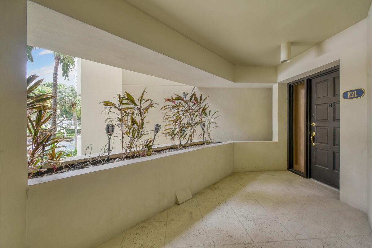 A covered outdoor entryway features a dark door labeled K2L and a built-in planter box — 1117 Marine Way E, North Palm Beach FL 33408, NORTH PALM BEACH, FL