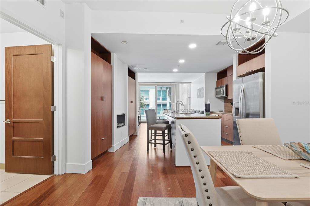A modern kitchen and dining area feature wood flooring, cabinetry, and a central island — 111 N 12TH STREET UNIT 1325, TAMPA, FL