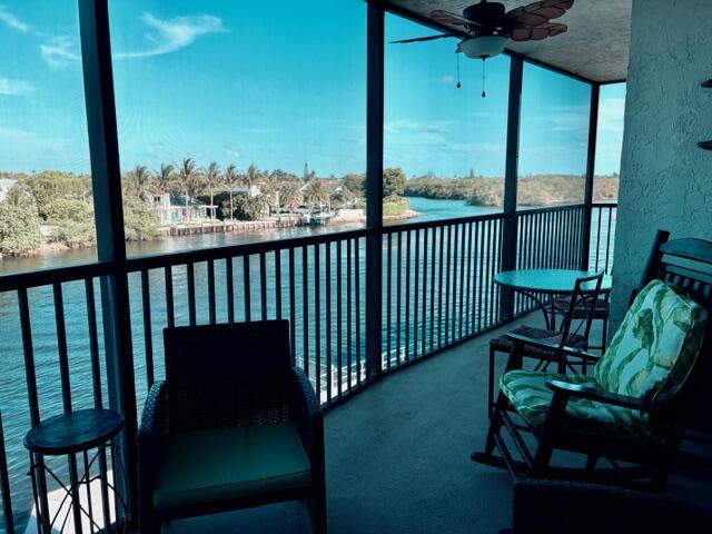 A screened-in balcony overlooks a waterway with palm trees and houses in the distance — 740 E Ocean Avenue # 407, Boynton Beach FL 33435, BOYNTON BEACH, FL