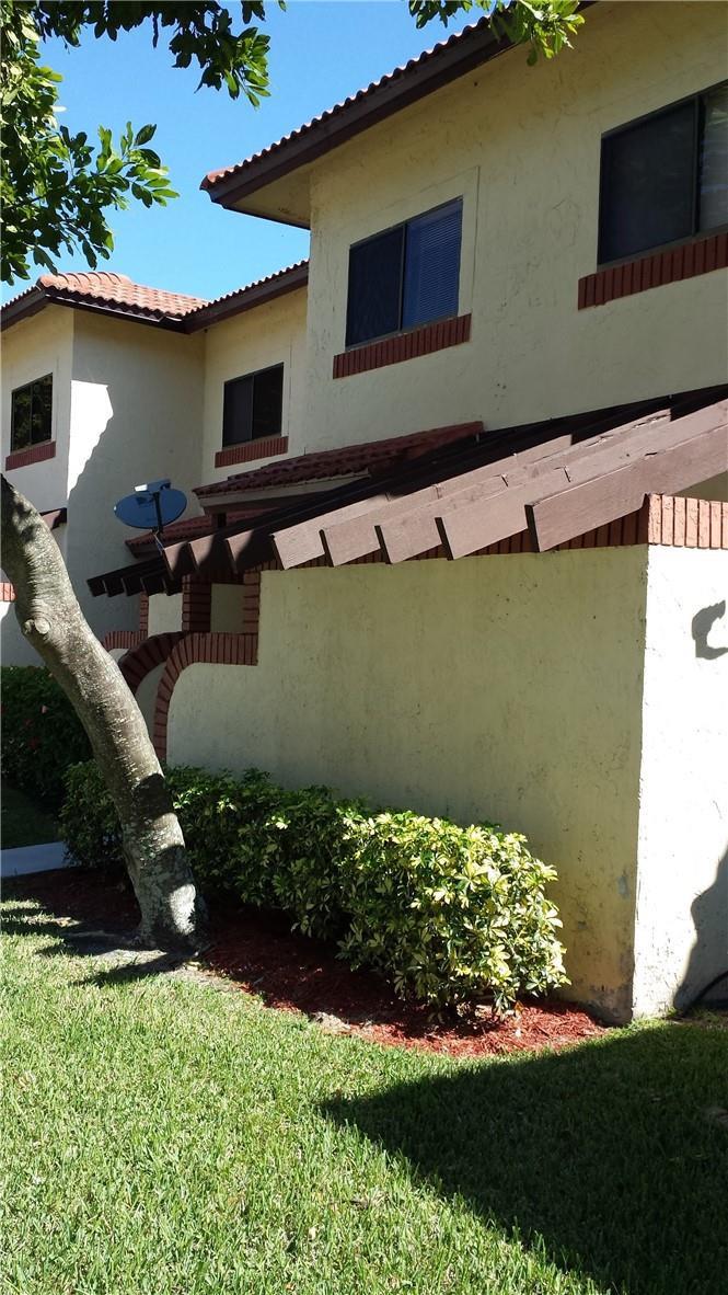 A two-story stucco building with a tiled roof, brown wooden trim, and landscaped bushes — 4728 NW 90th Avenue, Sunrise FL 33351, SUNRISE, FL
