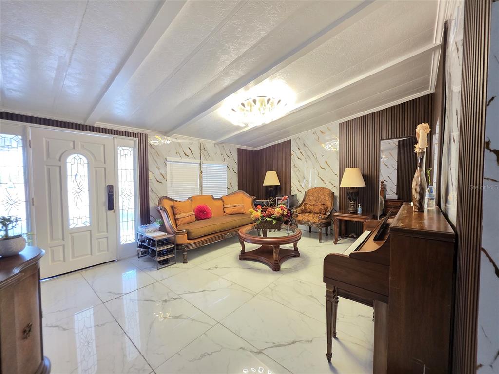 A living room features white marble-look tile flooring, wood-paneled walls, and a piano — 11344 ROCKRIDGE ROAD, LAKELAND, FL
