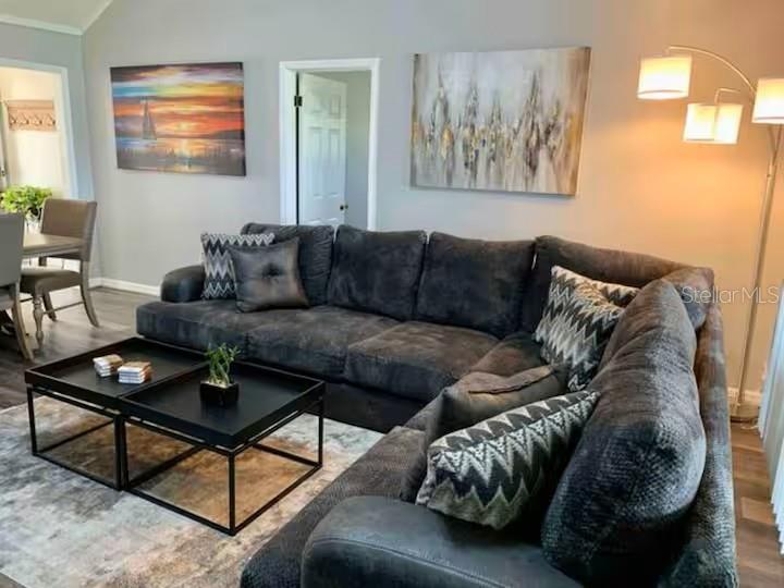 A living room features a large dark gray sectional sofa, two black coffee tables, and artwork — 1160 VILLA LANE UNIT 108, APOPKA, FL