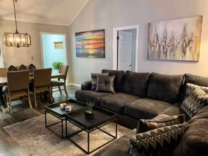 A living room features a large dark sectional sofa, two black coffee tables, and artwork — 1160 VILLA LANE UNIT 108, APOPKA, FL