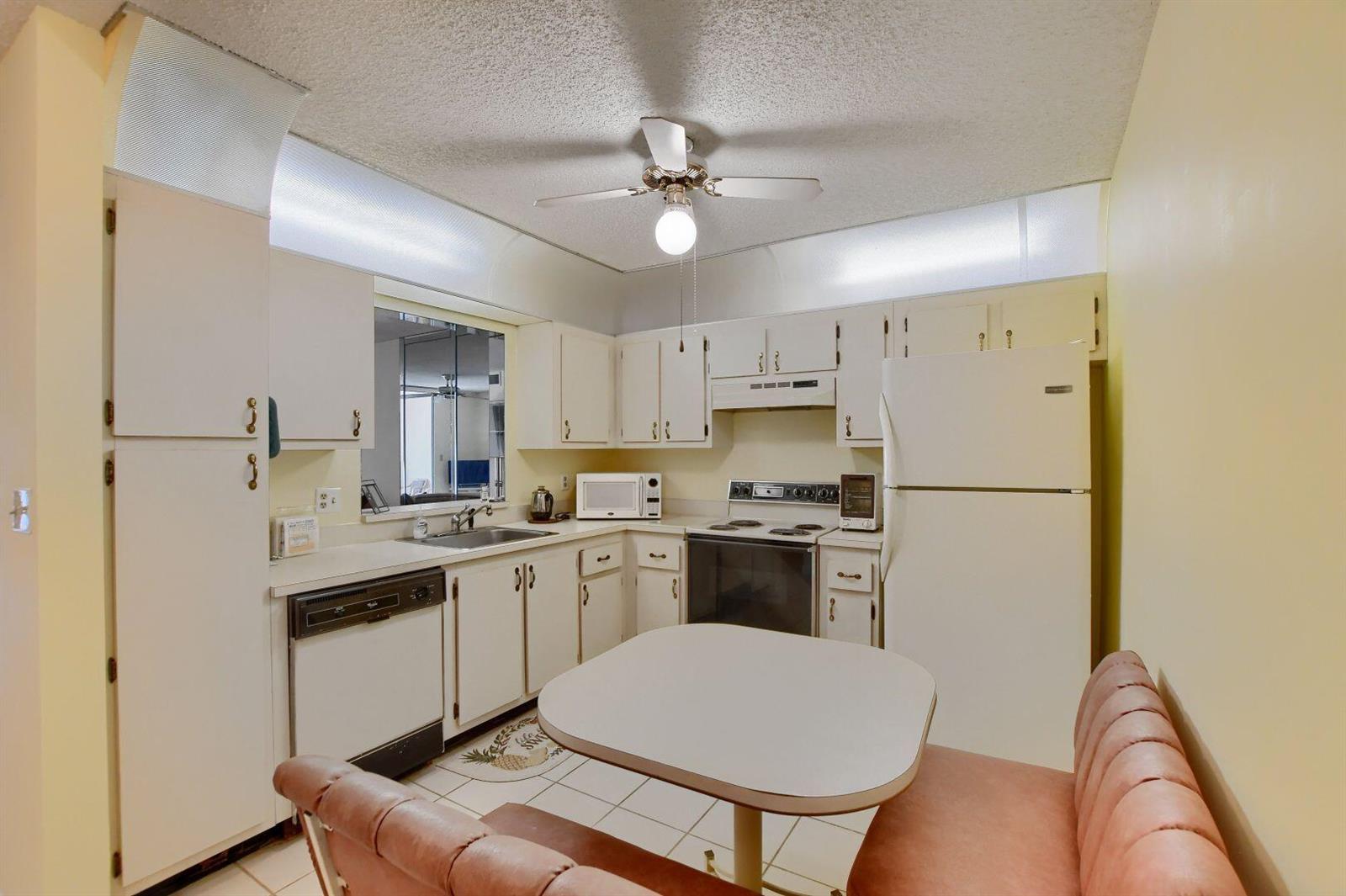 A kitchen with white cabinets, a dining nook, and a ceiling fan — 9244 Flynn Circle # 4, Boca Raton FL 33496, BOCA RATON, FL