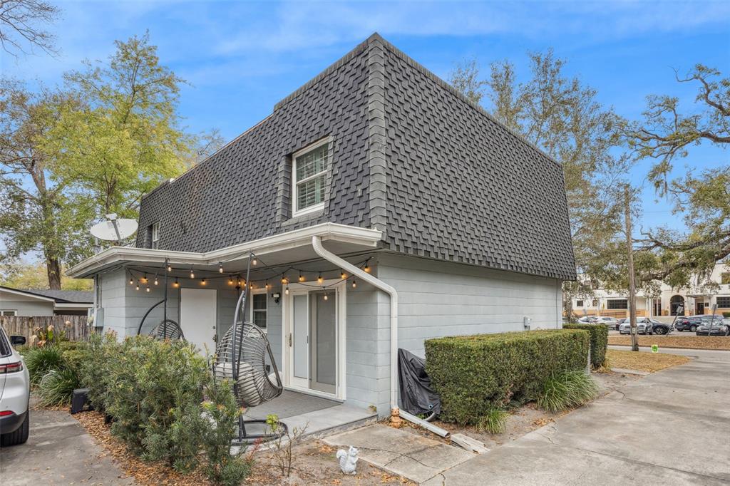 A two-story building with a shingled mansard roof and a covered patio with hanging chairs — 2218 ELIZABETH AVENUE UNIT 3, ORLANDO, FL