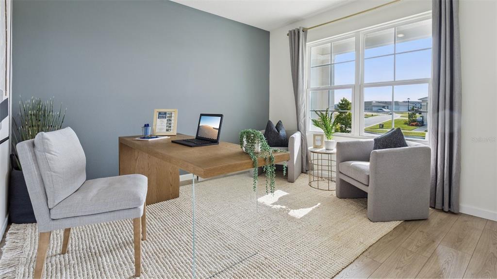 A home office features a wooden desk, two gray armchairs, and a large window — 4910 MARSHELDER STREET, APOPKA, FL