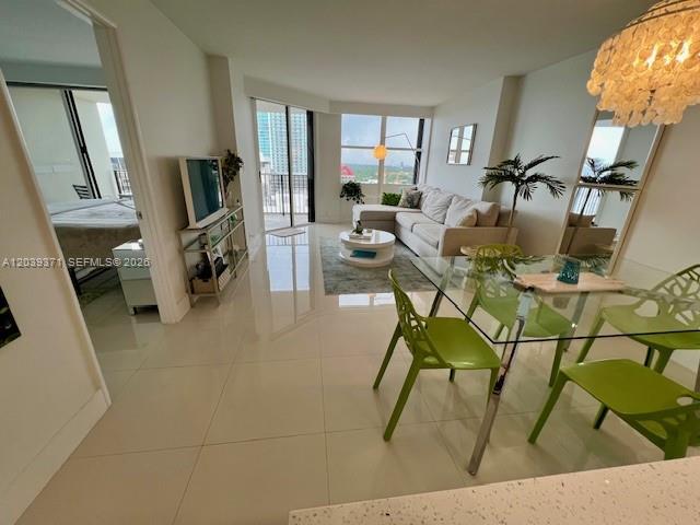 A modern living and dining area features tile floors, a glass table, and balcony views — 1901 BRICKELL AV # B2405, Miami FL 33129, MIAMI, FL