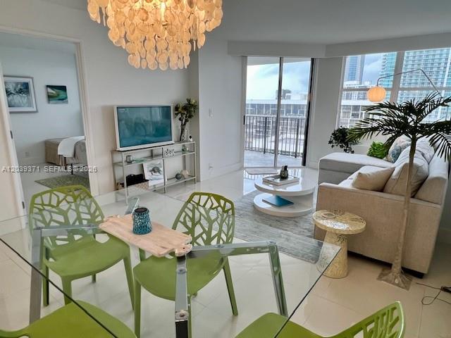A bright living and dining area features a glass table, green chairs, and balcony views — 1901 BRICKELL AV # B2405, Miami FL 33129, MIAMI, FL