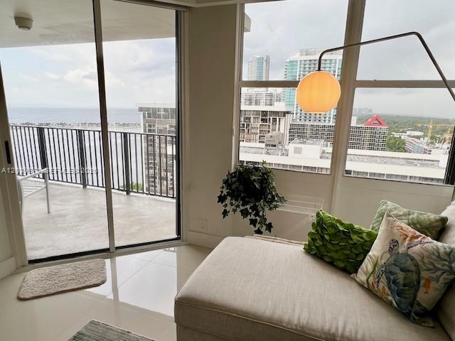 A living area features a beige chaise lounge, a floor lamp, and a balcony view — 1901 BRICKELL AV # B2405, Miami FL 33129, MIAMI, FL